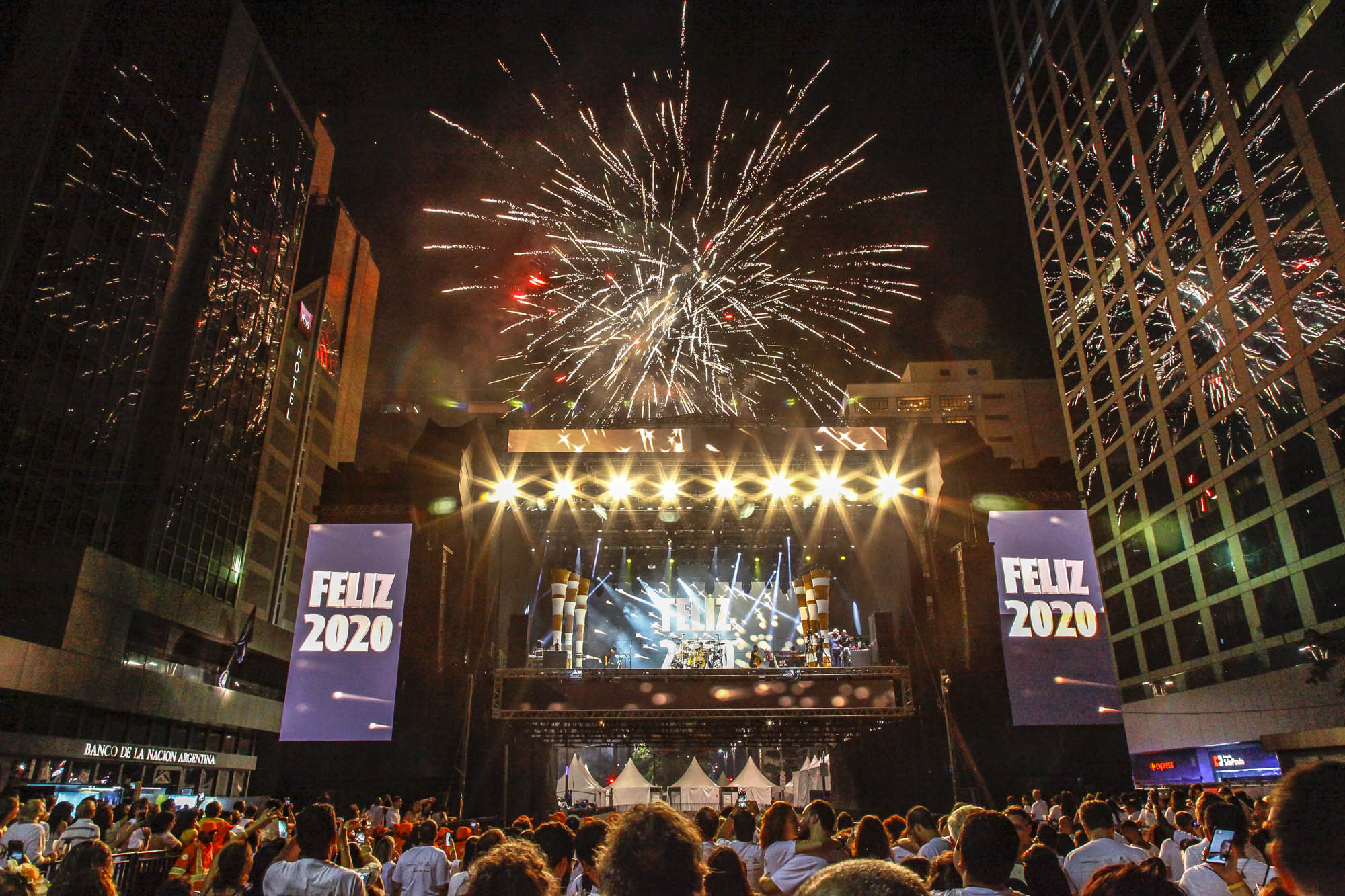 Foto do palco com fogos e escrito Feliz 2020